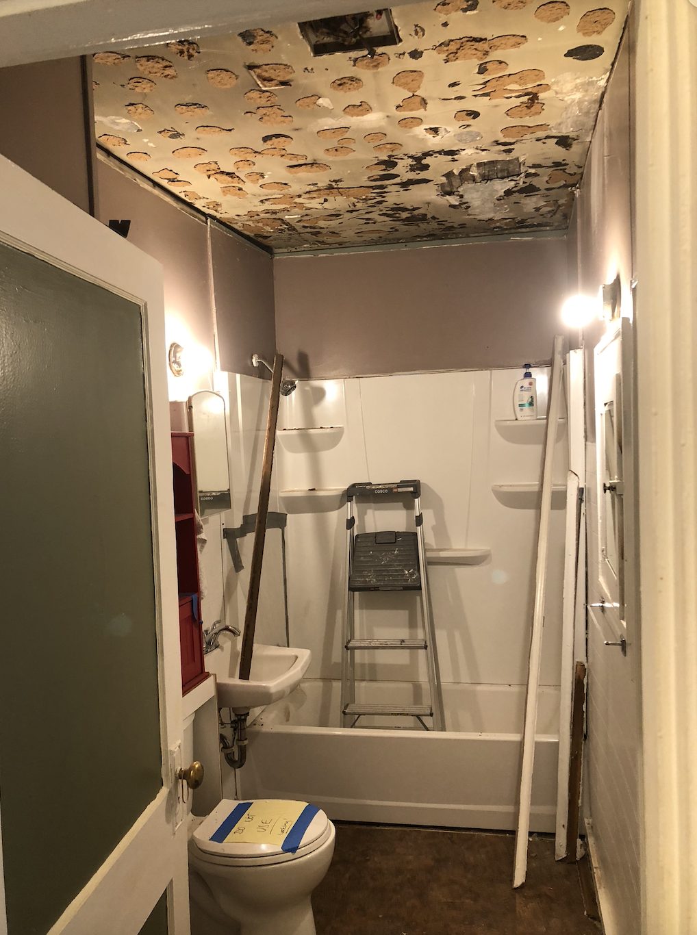 Bathroom before restoration: outdated fixtures and tile
