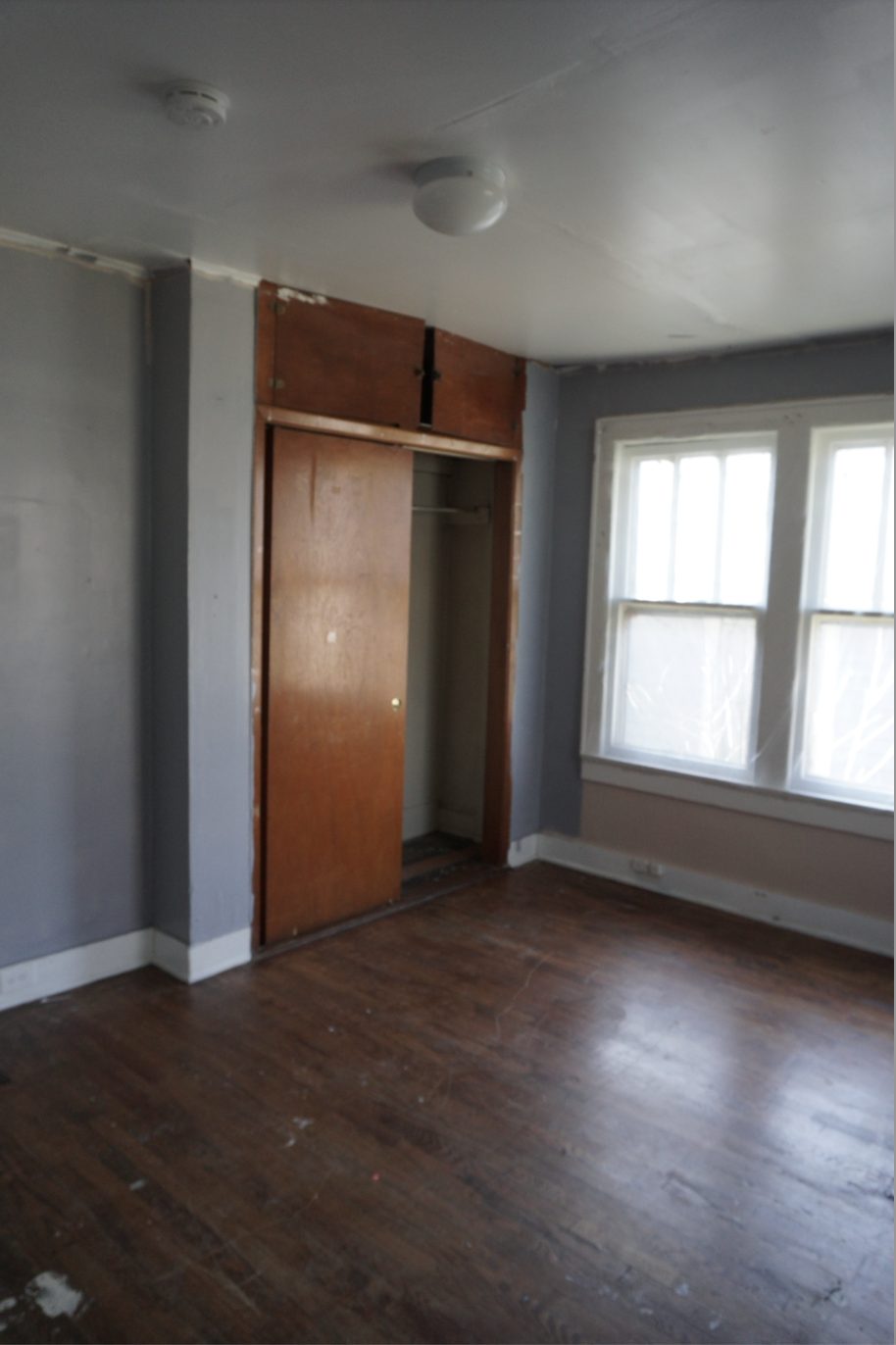 Bedroom before restoration: damaged walls and dated finishes
