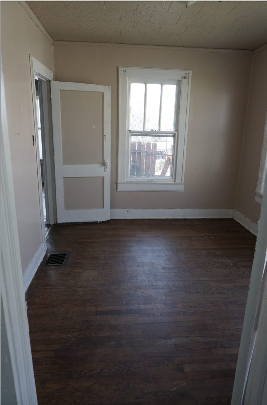 Living room before restoration: damaged plaster and worn finishes
